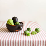Ceramic bowl with green veggies on a striped tablecloth