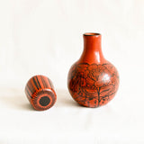 Terracotta Ceramic carafe with black floral patterns on a white background