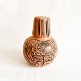 Peach Ceramic carafe with floral patterns on a white background