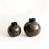 Black ceramic vases with engraved design on a white background