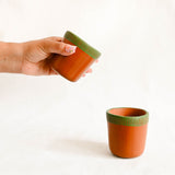 Ceramic cups with green textured rim on a white background