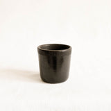 Black ceramic cup with textured design on a white background