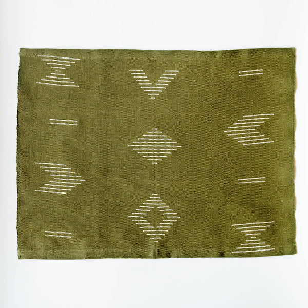 Handwoven forest green cotton dinner napkin and placemat featuring beige geometric designs