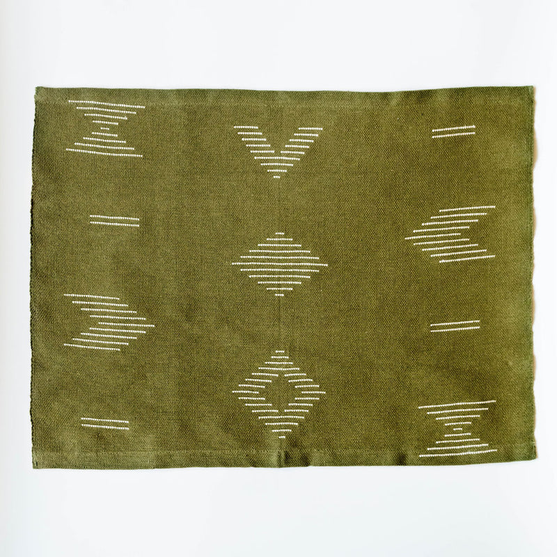 Handwoven forest green cotton dinner napkin and placemat featuring beige geometric designs