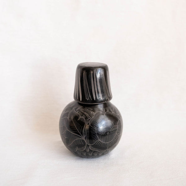handcrafted black ceramic bottle carafe with decorative patterns on a white background