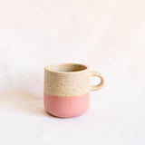 Pink and vanilla two-tone ceramic mug with a matte finish, rounded shape, and curved handle.