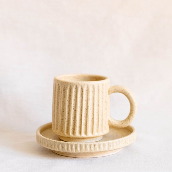 Vanilla Creme Mexican Ceramic Mug held by the handle with a soft, off-white finish and a smooth, matte texture. 