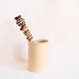 Handcrafted wooden molinillo hot chocolate frother with custom carved details in a ceramic kitchen utensil holder