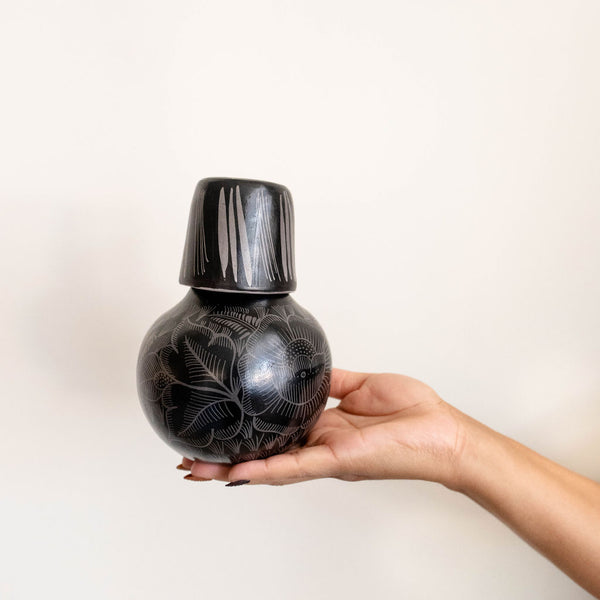 handcrafted black ceramic bottle carafe with decorative patterns on a white background