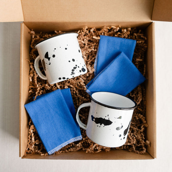 Sustainable gift set featuring two enamel cups and set of 5 reusable, cotton napkins. This gift box is designed for those who appreciate the perfect blend of bold colors and patterns, sustainability, and functionality.  This one-of-a-kind gift set includes a set of enamel (peltre) cups. The unique designs are hand drawn and inspired by the art of the Mexican state of Michoacán. Made for everyday use, these durable enamel cups are a timeless, modern addition to your casita. 
