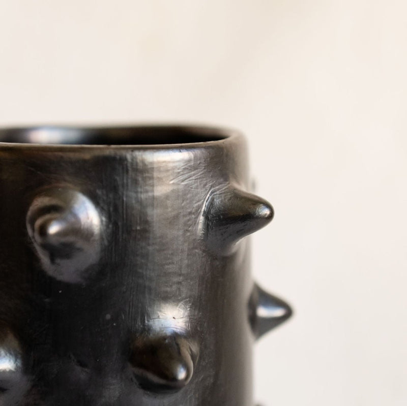 Closeup of a handcrafted Spiked Black Clay Cup made from authentic Mexican black clay (barro negro), featuring a bold spiked design with a smooth black metallic finish. Perfect for modern drinkware or as a unique artisanal decor piece.