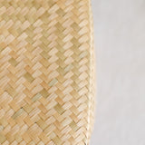 Close up of the handwoven Palm Lidded Basket with natural palm leaf texture. The basket features a tightly woven design with a matching lid, showcasing artisanal craftsmanship from Mexico. Perfect for eco-friendly storage, the basket exudes a minimalist and earthy aesthetic.