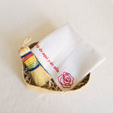 Nube Mexicano Cleaning Rituals Gift Basket, featuring a soft white Jerga cloth, a vibrant rainbow-colored Escobeta brush, and a large handwoven palm basket. The set combines traditional Mexican cleaning essentials, beautifully arranged for a practical and aesthetically pleasing presentation.