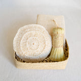 Agave Rituals Gift Basket featuring an assortment of agave-based self-care items, including a hand dish brush (Escobeta) available in beige, an Ayate washcloth, and a large agave body sponge, all neatly arranged in a handwoven palm gift basket.