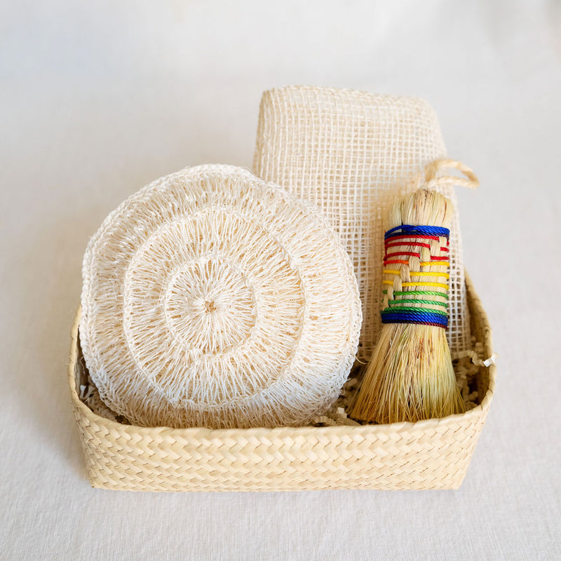 Agave Rituals Gift Basket featuring an assortment of agave-based self-care items, including a hand dish brush (Escobeta) available in rainbow, an Ayate washcloth, and a large agave body sponge, all neatly arranged in a handwoven palm gift basket.