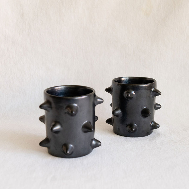 Two handcrafted Spiked Black Clay Cup smade from authentic Mexican black clay (barro negro), featuring a bold spiked design with a smooth black metallic finish. Perfect for modern drinkware or as a unique artisanal decor pieces.