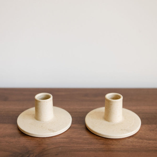 Two elegant Vainilla Creme Ceramic Candle Holder with a smooth, creamy finish and minimalist design. The holder features a gently curved shape, perfect for holding tapered candles, adding a touch of warmth and sophistication to any space.