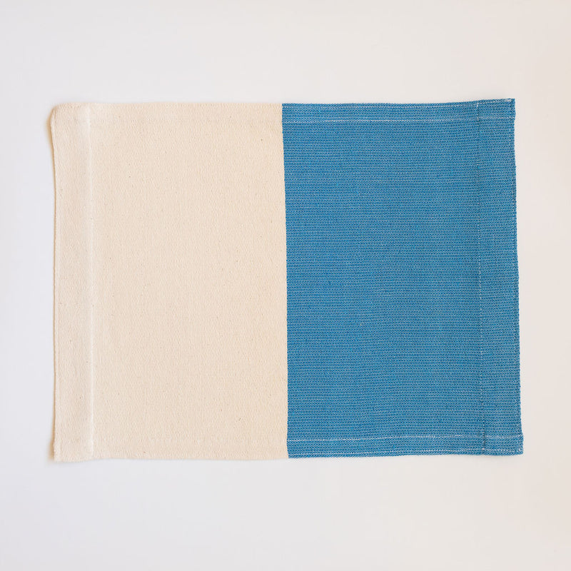 Handwoven cotton placemat on a pedal loom in color block design with half Azure Blue and half neutral