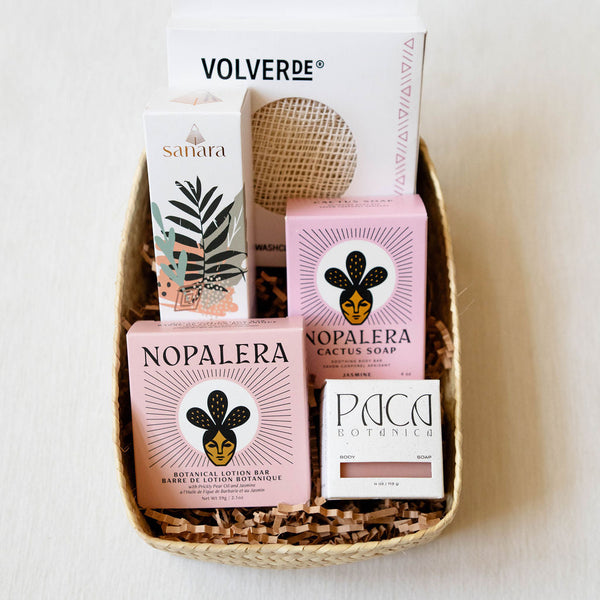 Basket with Nopalera, and Sanara skincare products on a white background. Includes Ayate washcloth, body oil, lotion bar, and soap bars