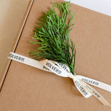 Gift wrapped in brown paper with a green branch and 'Volverde' ribbon.