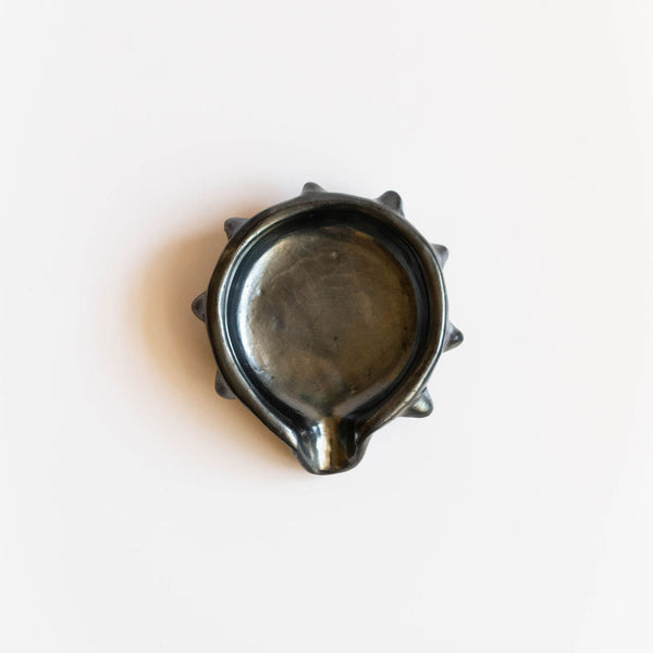 Metallic black barro negro ceramic soap dish with spiked rim on a white background