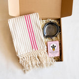 Handwoven pink-accent cotton kitchen towel displayed with an Oaxacan black smoked clay spiked soap dish and a Nopalera Flor de Mayo Jasmine Cactus Soap Bar arranged together as a Rosa Mexicana Home Ritual Gift Box.
