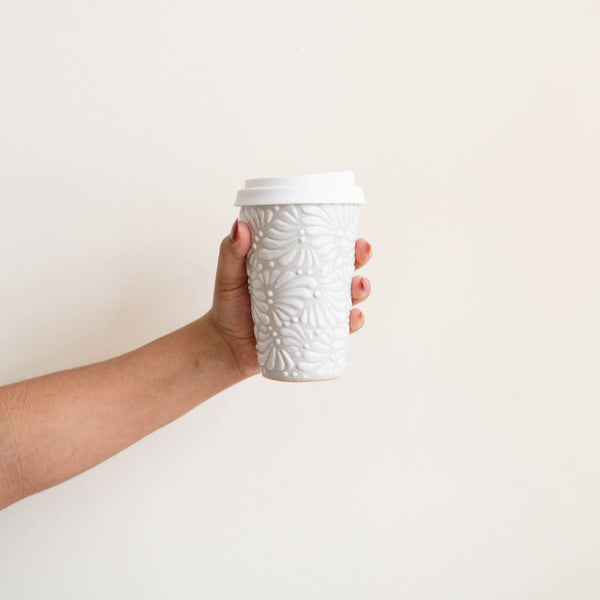 White Talavera Ceramic Coffee Tumbler with silicone white lid held by a hand. Featuring intricate, traditional Mexican ceramics in bold, fade-resistant colors. 