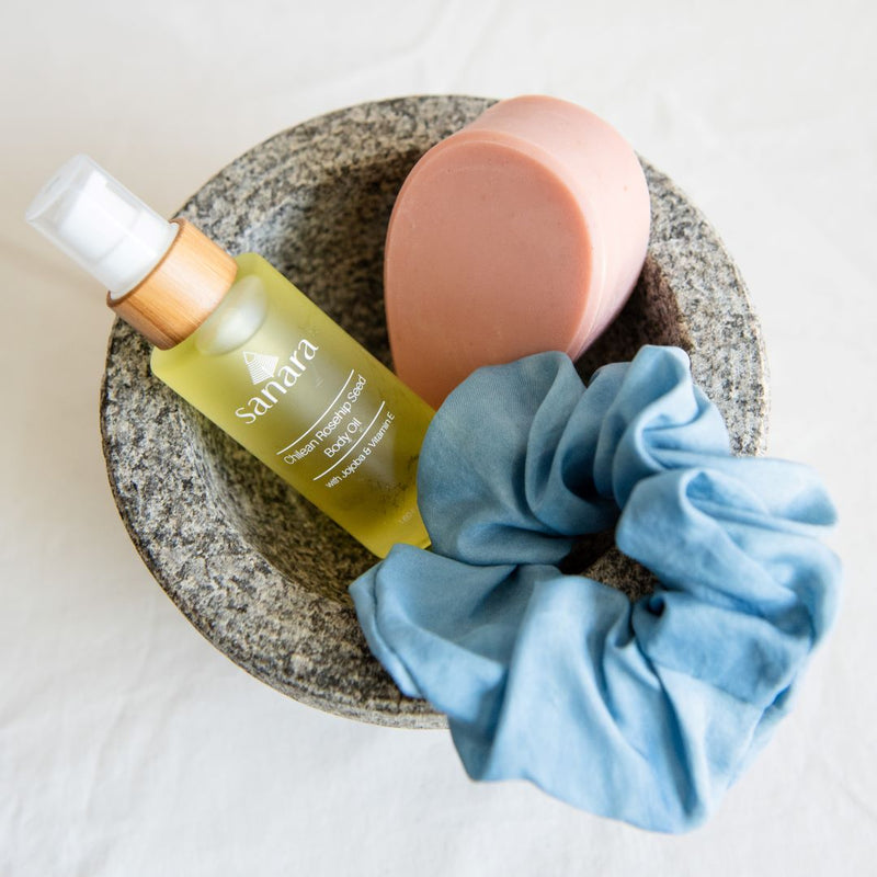 Sustainable gift sets including three latina-owned brands: Nopalera soap, Sanara Skincare and Gu Shu. Pink Flor de Mayo Nopalera Soap. Blue Silk Scrunchie.