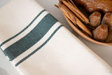 A closeup of the natural cotton weave with hunter green stripes achieved from the handwoven weaving process