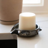 Black barro negro ceramic soap dish with spiked rim on a white countertop next to a kitchen sink