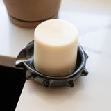 Black barro negro ceramic soap dish with spiked rim on a white countertop next to a kitchen sink