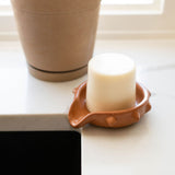a terracotta ceramic soap dish on a sink with round soap bar