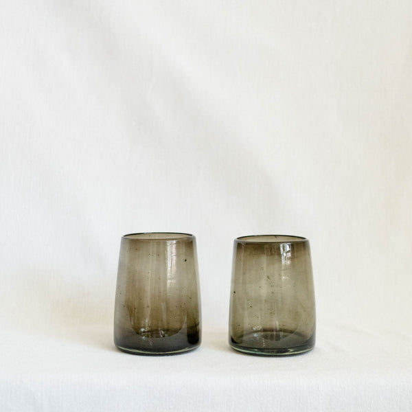 Two smoked glass tumblers on a white background