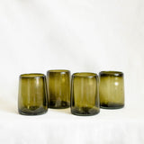 Four green glass tumblers on a white background
