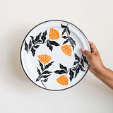 Enamel Peltre serving platter in white with delicate orange floral accents inspired by the cempasúchil flower. The platter features a smooth, glossy finish and a slightly raised edges for easy carrying, perfect for serving snacks, or as a decorative centerpiece.