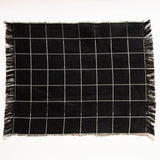 Black and white checkered napkin with frayed edges on a white background