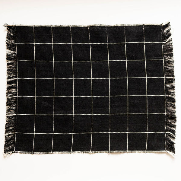 Black and white checkered napkin with frayed edges on a white background