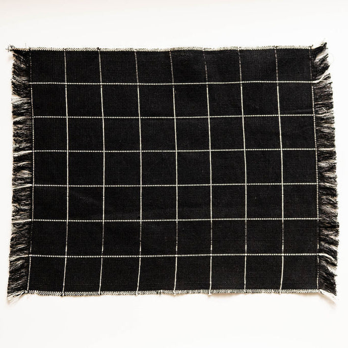Black and white checkered napkin with frayed edges on a white background
