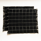 Black and white checkered napkins with frayed edges on a white background
