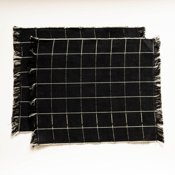 Black and white checkered napkins with frayed edges on a white background