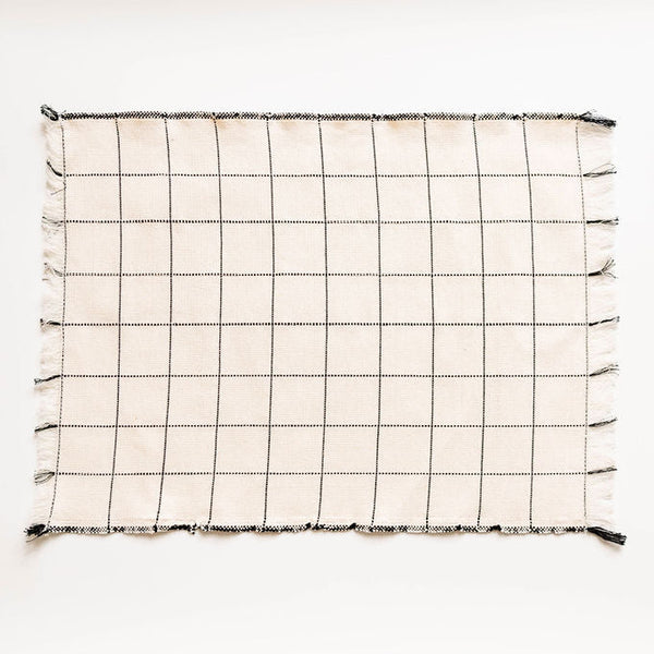 Grid-patterned napkin with tassels on a white background
