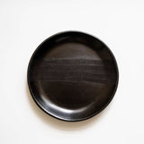 Black ceramic plate on a white background