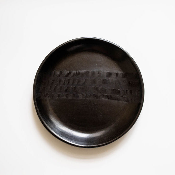 Black ceramic plate on a white background