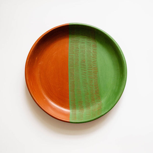 Ceramic plate with orange and green design on a white background