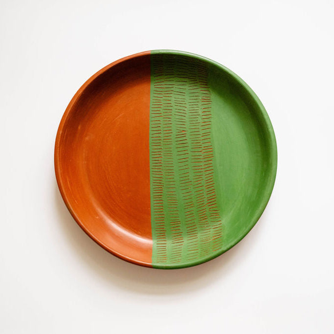 Ceramic plate with orange and green design on a white background
