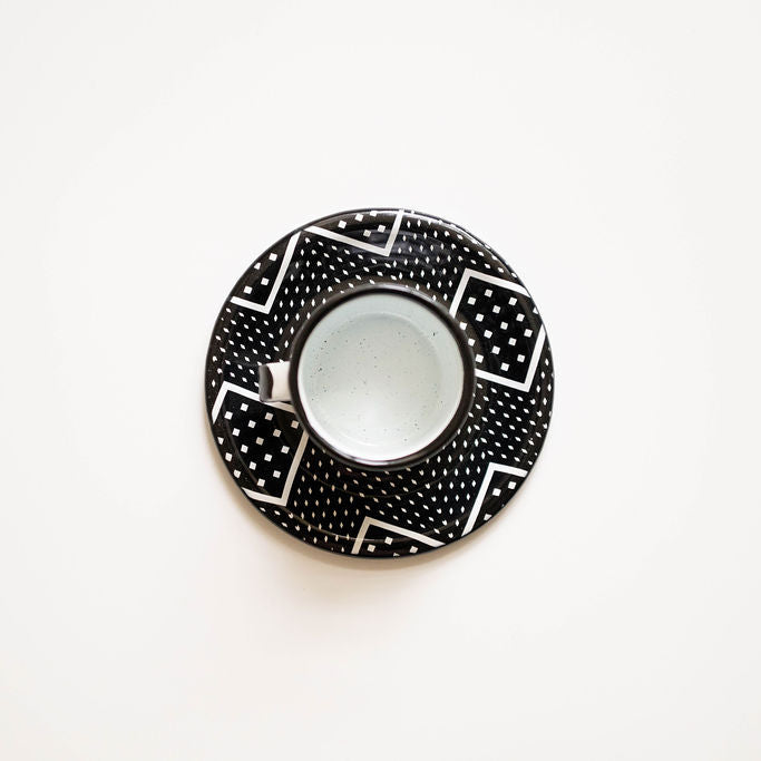 Black and white patterned saucer with a matching express cup on a white background