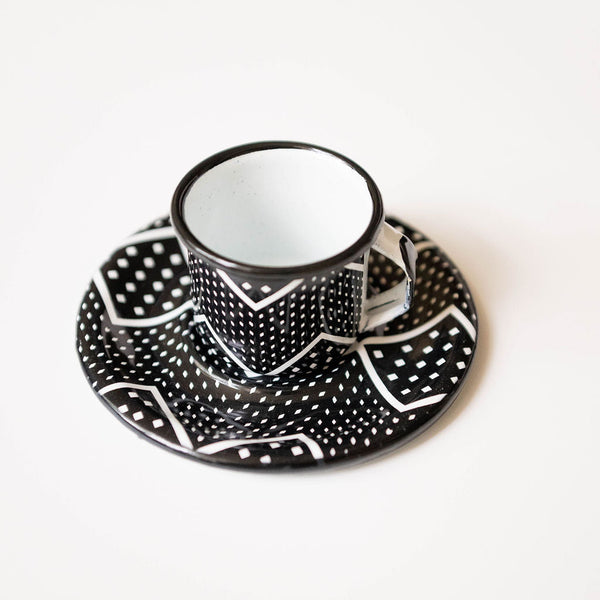 enamel expresso cup and saucer with black and white geometric pattern on a white background