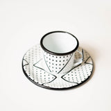 Metal Expresso cup and saucer with black dot patterns on a white background