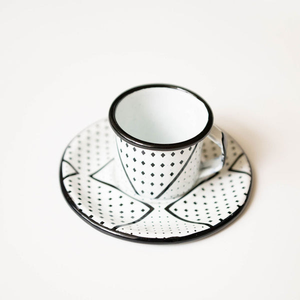 Metal Expresso cup and saucer with black dot patterns on a white background