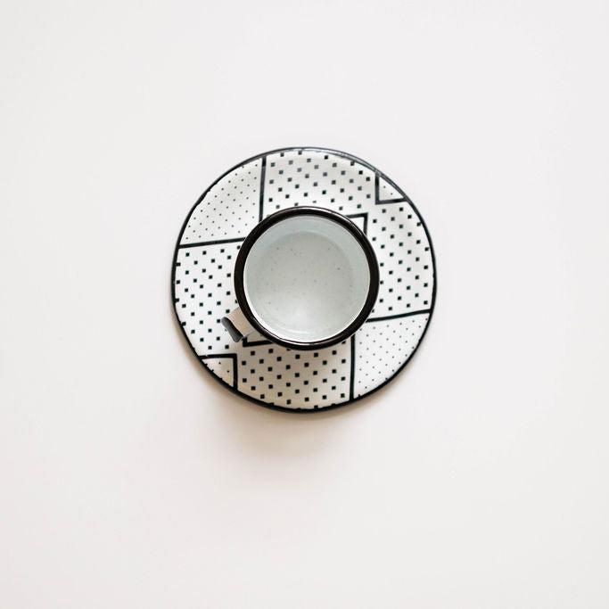 Expresso cup and saucer with geometric pattern on a white background